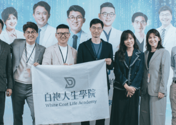 Group of professionals posing with a banner reading White Coat Life Academy.